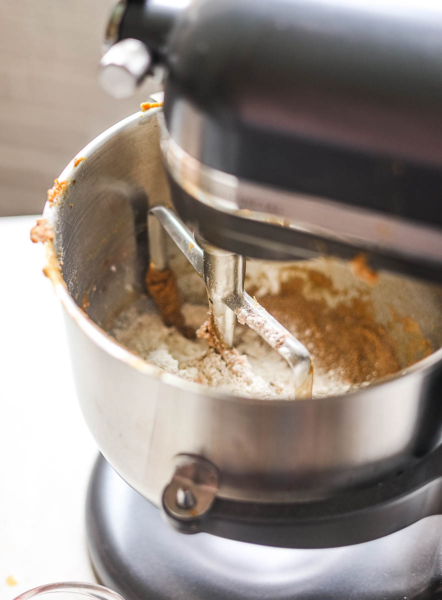 This image is a process image for the Gluten Free Gingerbread Bundt Cake. It shows the step where the wet and dry ingredients are being added alternately into the mixer