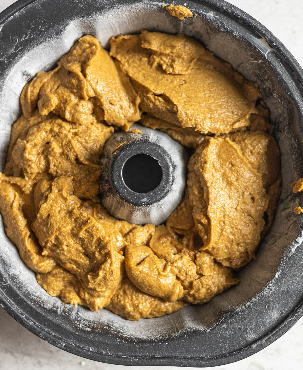 This image is a process image for the Gluten Free Gingerbread Bundt Cake. It shows the step where the cake batter has been poured into a prepared pan.