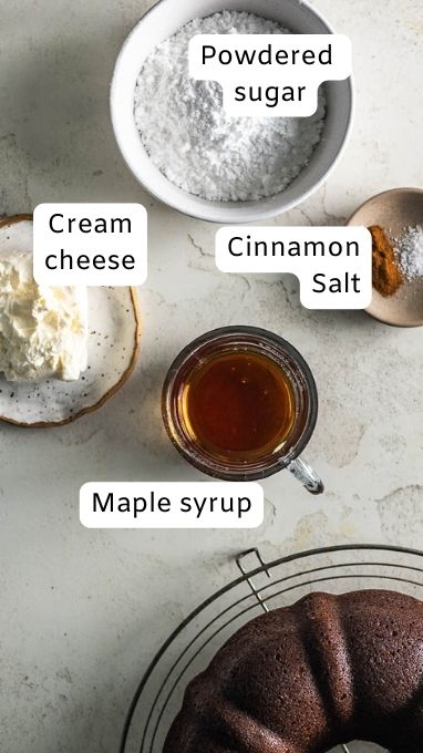 Ingredient image for the Maple Cream Cheese Glaze that goes on top of the Gluten Free Gingerbread Bundt Cake. This image shows powdered sugar, cream cheese, cinnamon, salt, and maple syrup