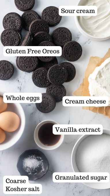 Ingredients for the filling for the Gluten free oreo cheesecake. This image shows the oreos, sour cream, cream cheese, granulated sugar, vanilla extract, salt, and eggs.