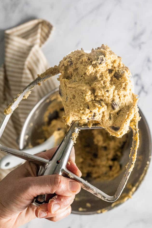 This image shows the completed oat flour chocolate chip cookie dough. It's a super creamy and thick cookie dough. The image pictured is the paddle attachment for the mixer.