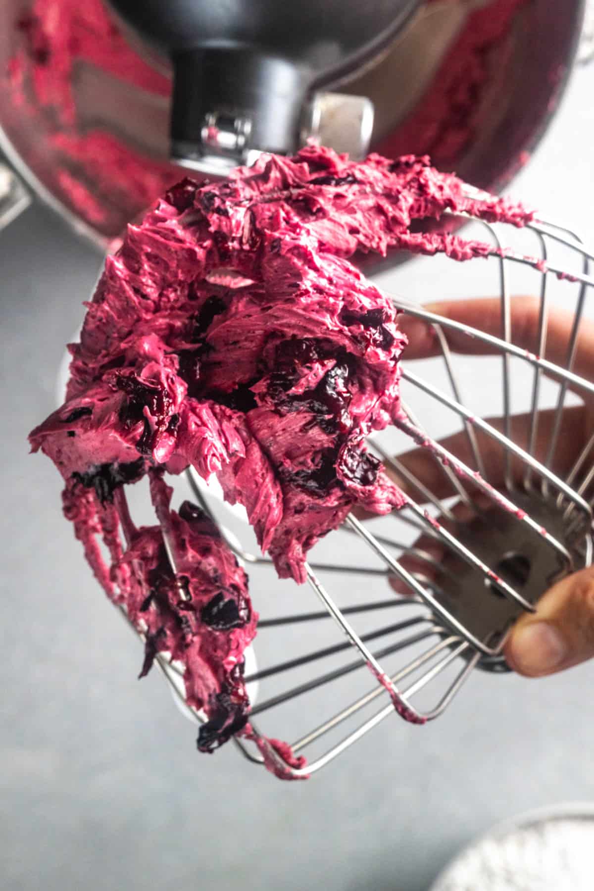This image shows the blueberry frosting mixture once the blueberries and butter have been well combined, but before the sugar, vanilla extract, and salt have been added. It a very deep, rich purple.