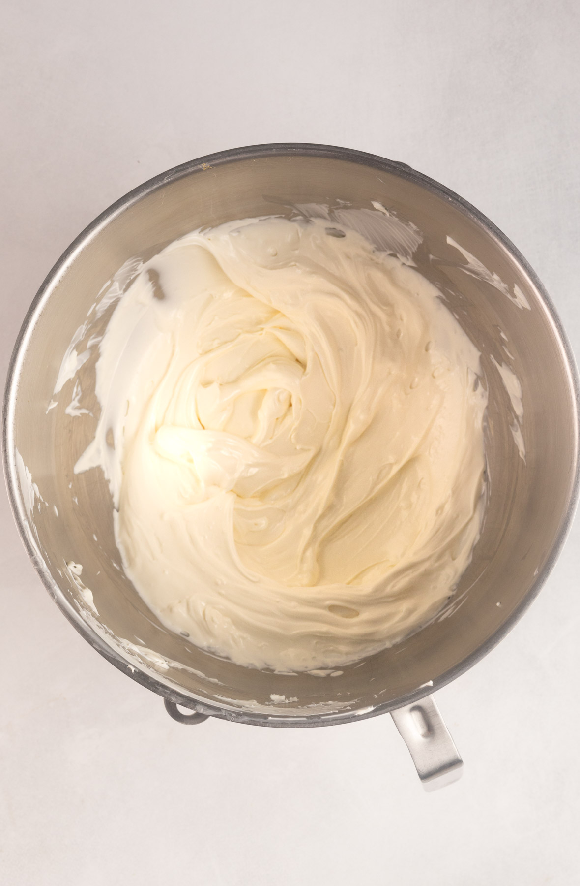 Image shows creamed together sour cream and cream cheese for gluten free pumpkin cheesecake.