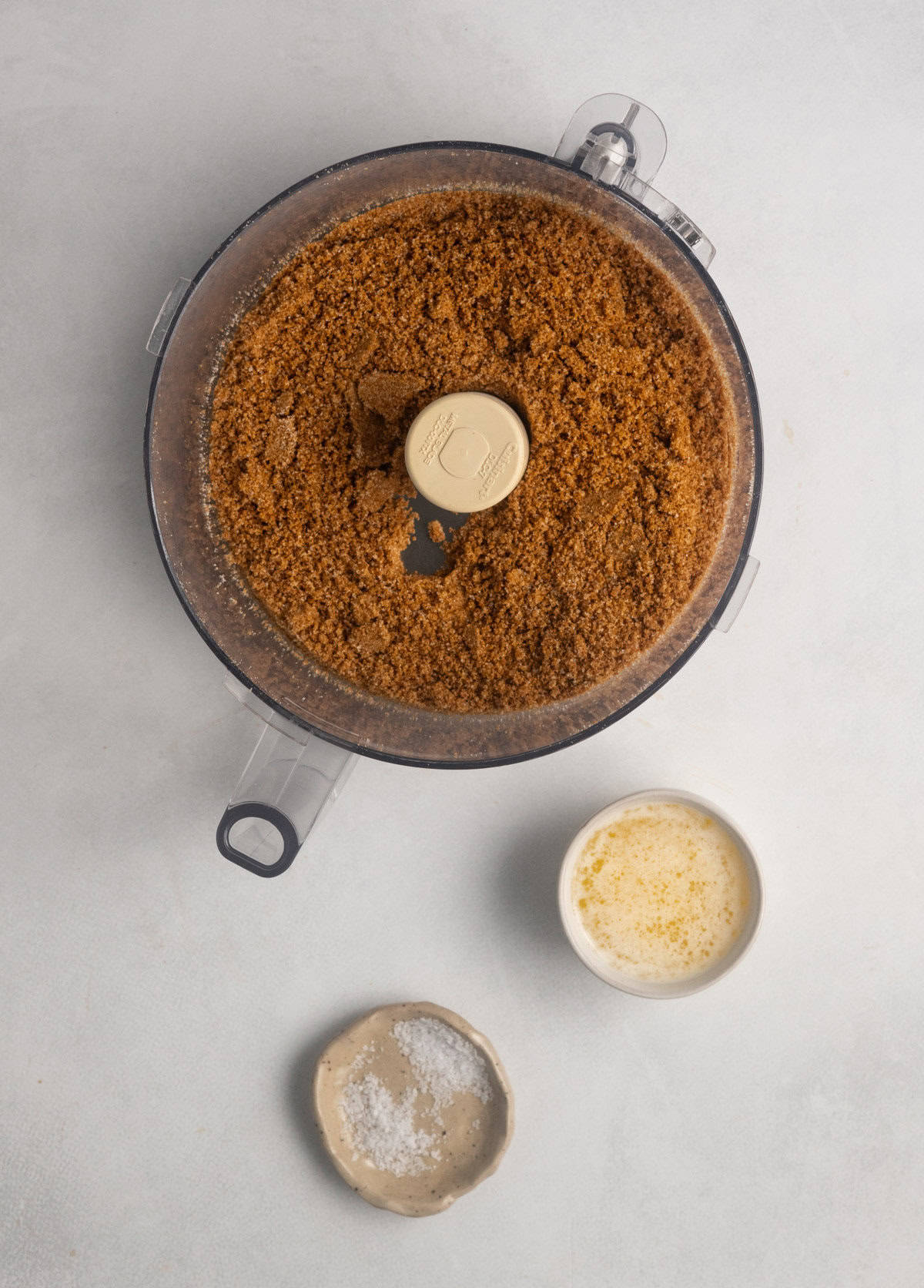 Image shows the pulverized gluten-free gingersnaps and granulated sugar used for gluten free pumpkin cheesecake.