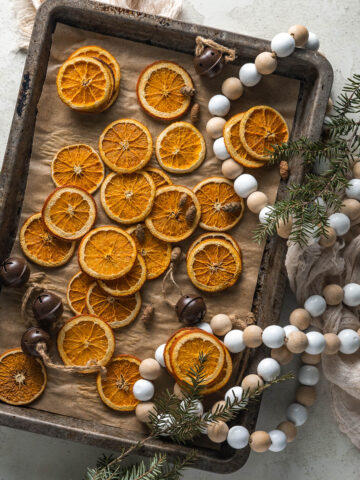 Tray of orange slices scattered across it with subtle holiday decor