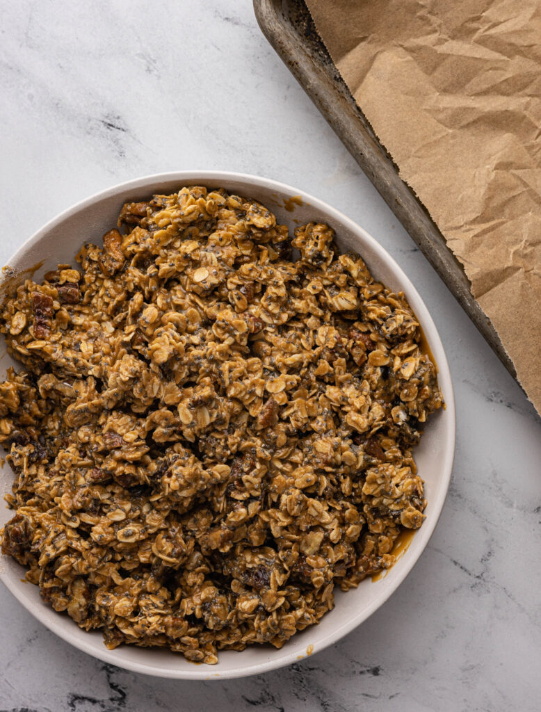 Peanut butter granola clusters mixed in a bowl, before baking.