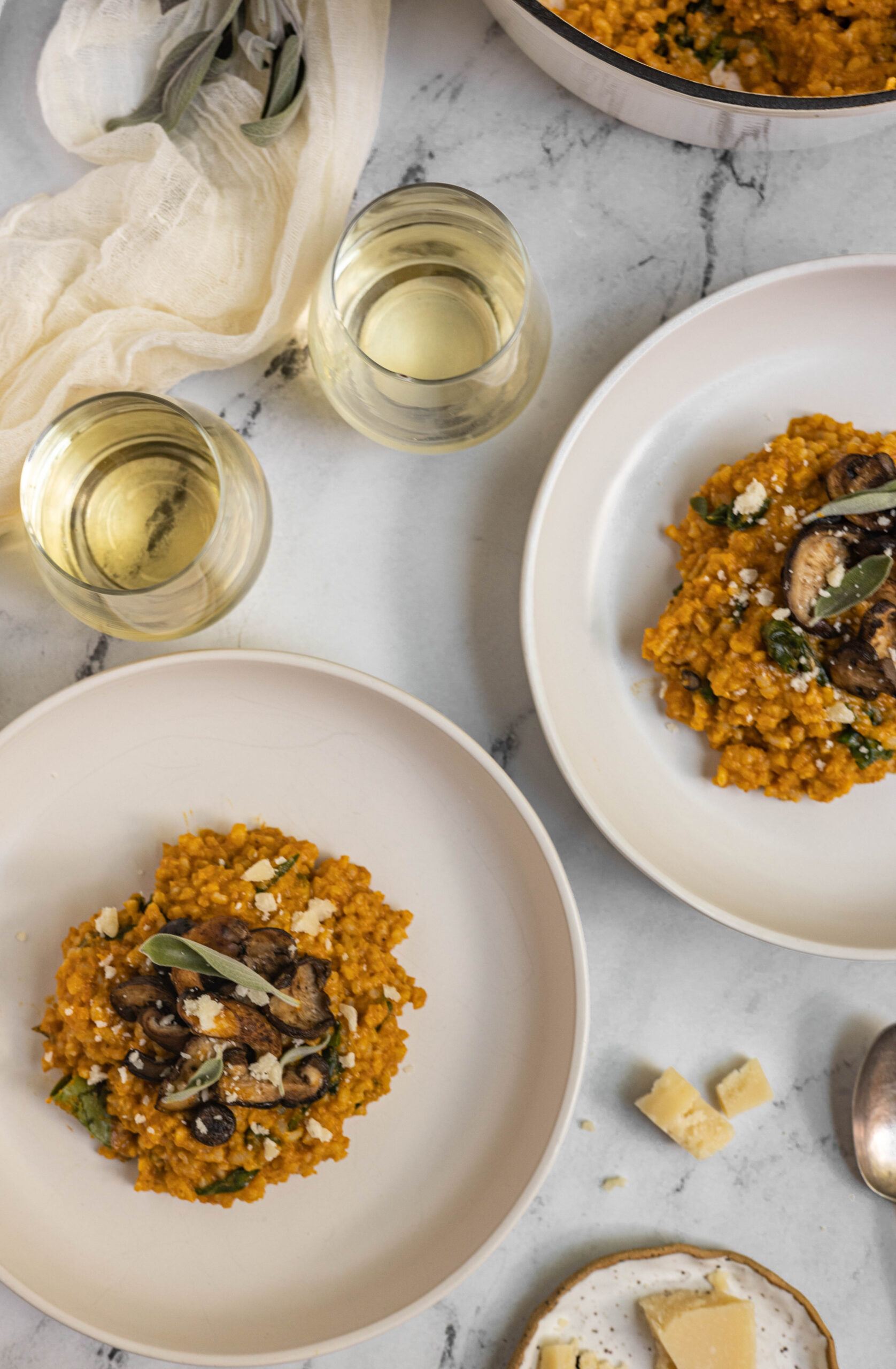 Table scape image of pumpkin and mushroom risotto.