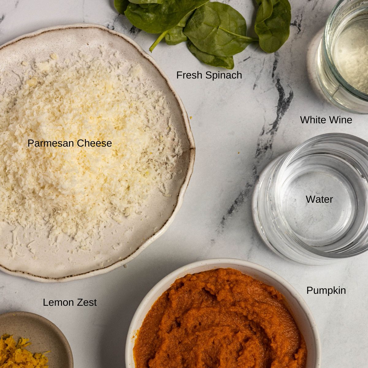 Ingredient image for Pumpkin and Mushroom Risotto. Shows fresh spinach, grated parmesan cheese, white wine, water, pumpkin, and lemon zest.